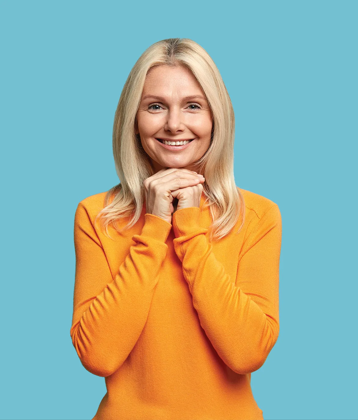 A smiling woman in an orange jumper