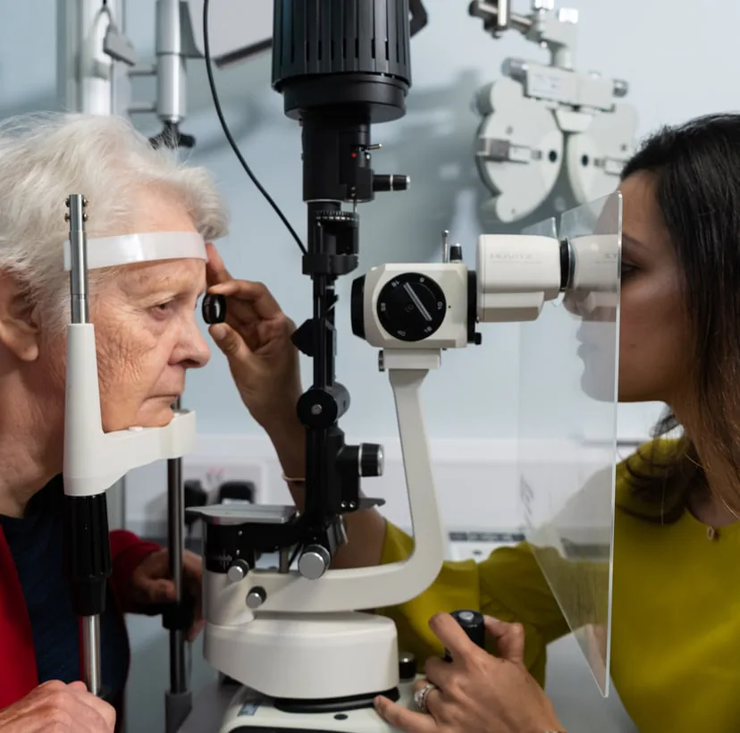 An optometrist examining a patient's eyes with a slit lamp