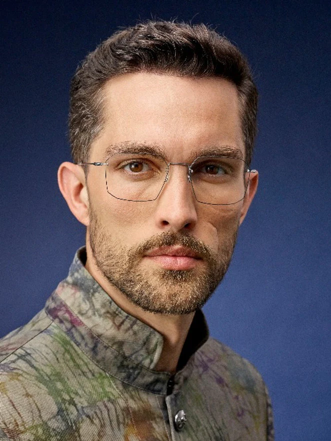 A man wearing rimless Lindberg glasses