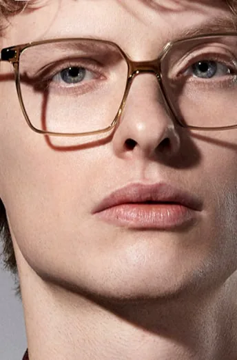 A close-up of a model wearing tortoiseshell glasses