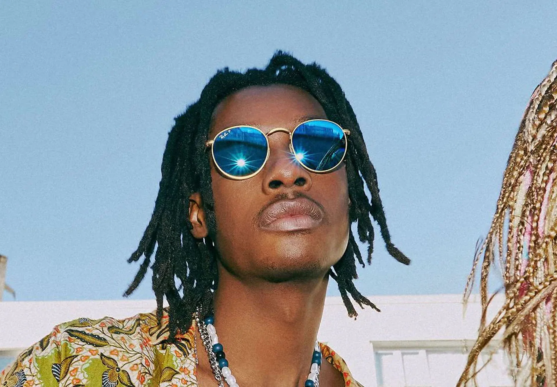 A model wearing round Ray-Ban sunglasses