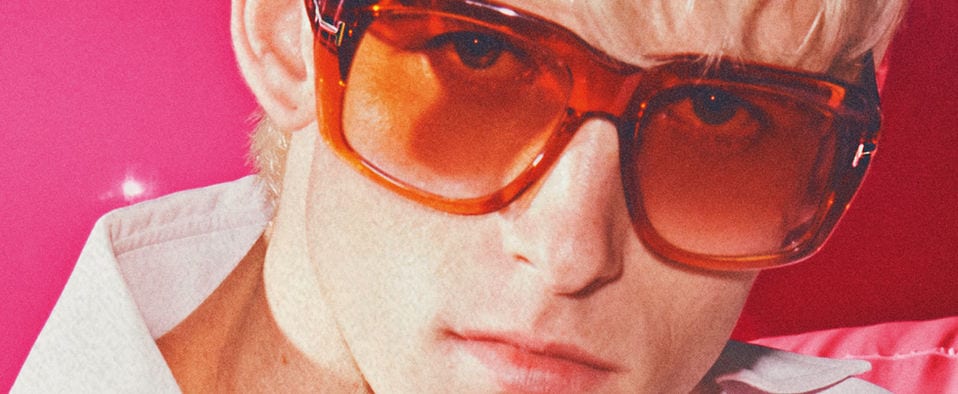 A model wearing Tom Ford sunglasses with orange lenses